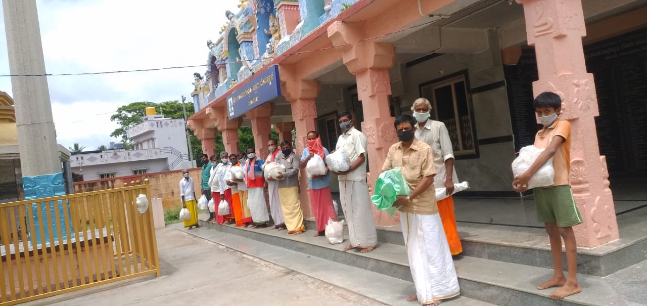 Families receiving 40-day food kits at the temple distribution point.