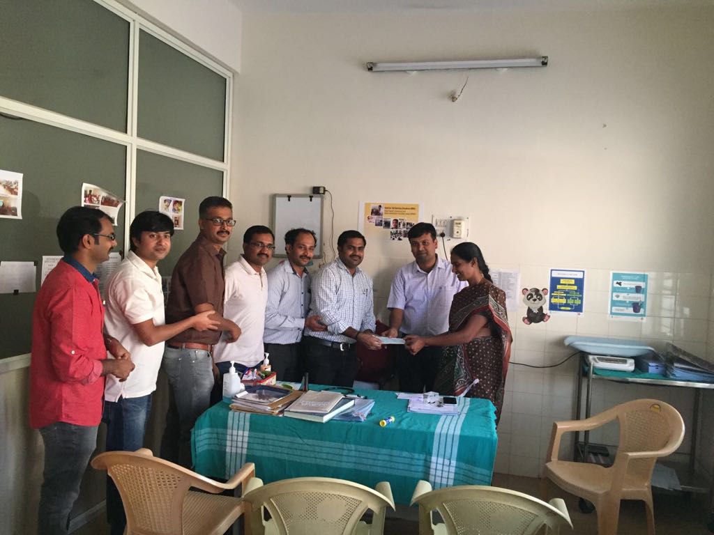 Hongirana trustees handing over a hearing aid to the mother of a young child at the Mysore District Early Intervention Centre